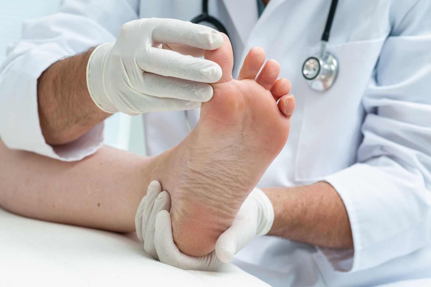 Podiatrist examines the foot of a patient