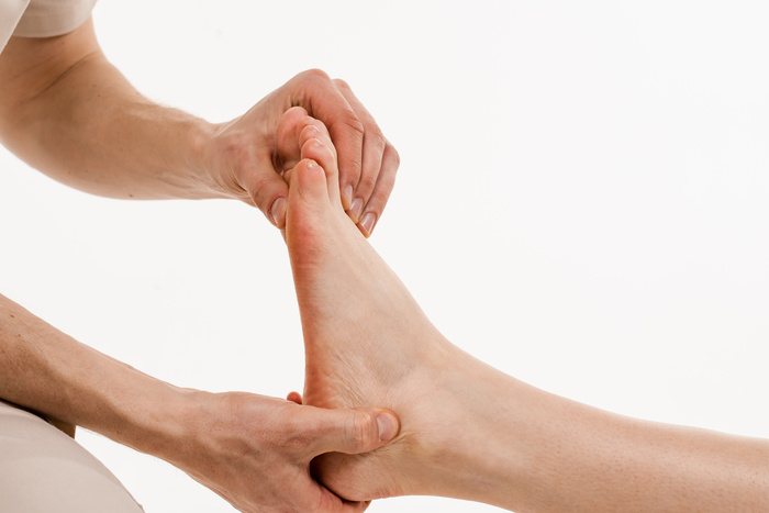 Foot close up: podiatrist is touching and pressing the foot for assessment